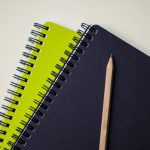 green and black notepads with pencil