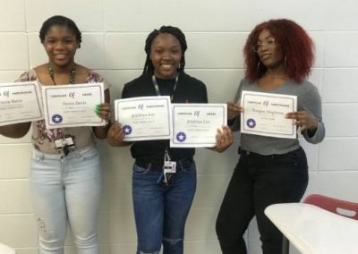 three African American teen girls holding certificates