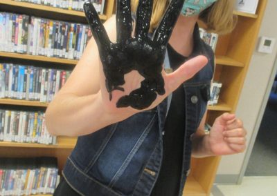 hand with black paint on it for the spider