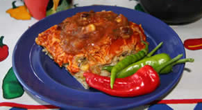 enchiladas with red and green peppers on a blue plate