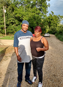 African American American man and woman in casual wear standing in the street. Forest background.