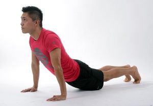 Asian man in yoga pose on white background.