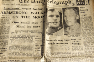 Picture of the front of The Daily Telegraph newspaper with headline of ARMSTRONG WALKS ON THE MOON. Pictures of Neil Armstrong and Buzz Aldrin on the right.