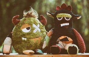 two stuffed toy monsters, green and black