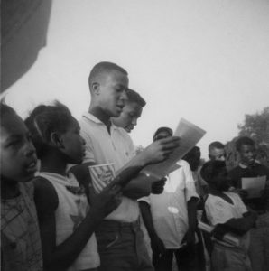 group of African American youth and young adults standing in a row holding flyers
