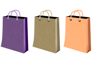 illustration of three shopping bags - purple, taupe and peach.