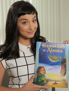 Caucasian woman with dark hair holding a children's book