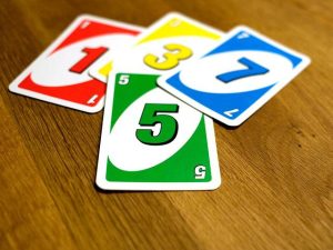 four UNO cards on a wooden tabletop